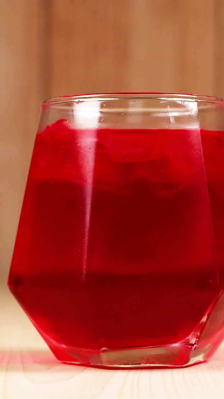 Mano afferra una bevanda rossa