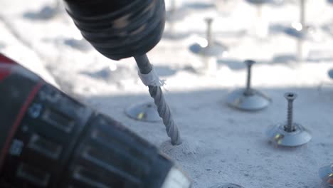 instalación de tornillos en el hormigón con un taladro eléctrico