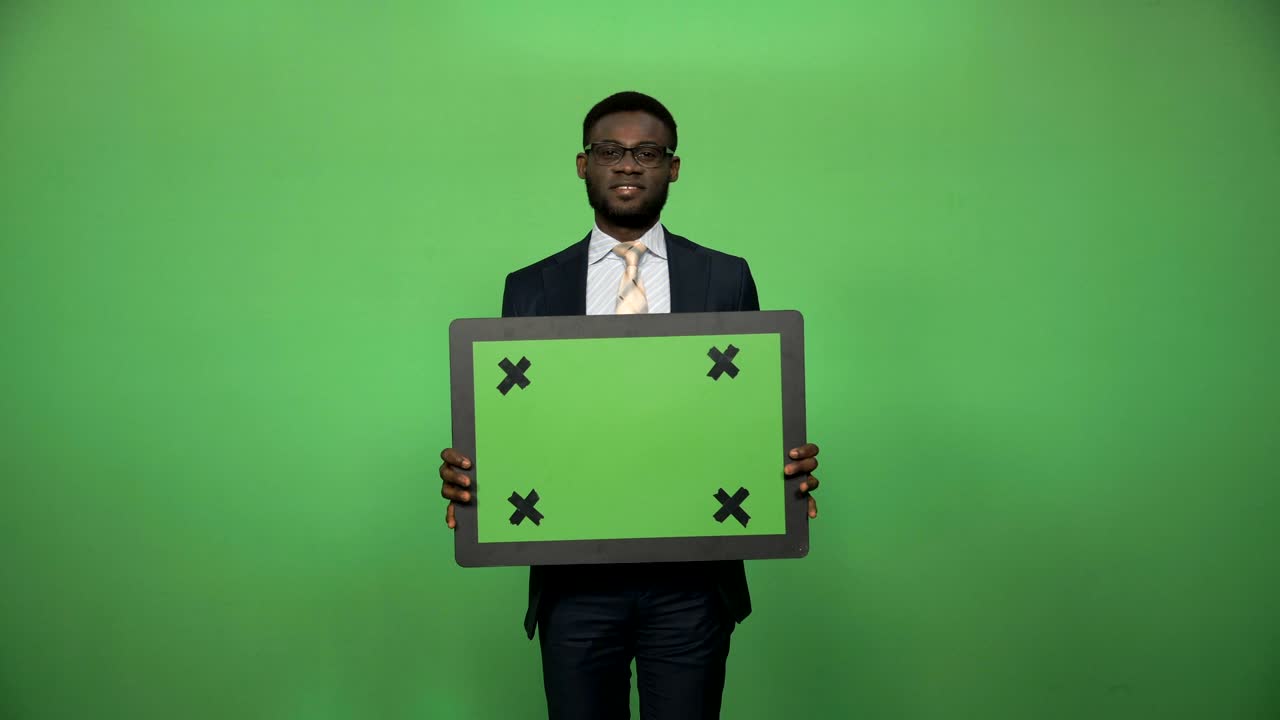 Smiling african businessman holding chromakey board