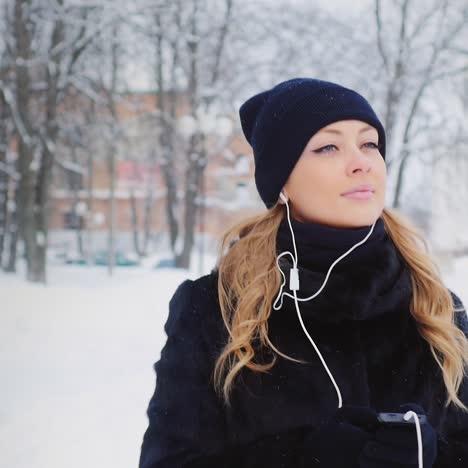 Woman-Walks-And-Listens-To-Music-In-Wintery-Park-01