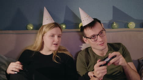 couple playing video games at home party