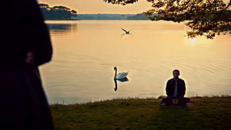 couple meditating by the lake at sunrise/sunset
