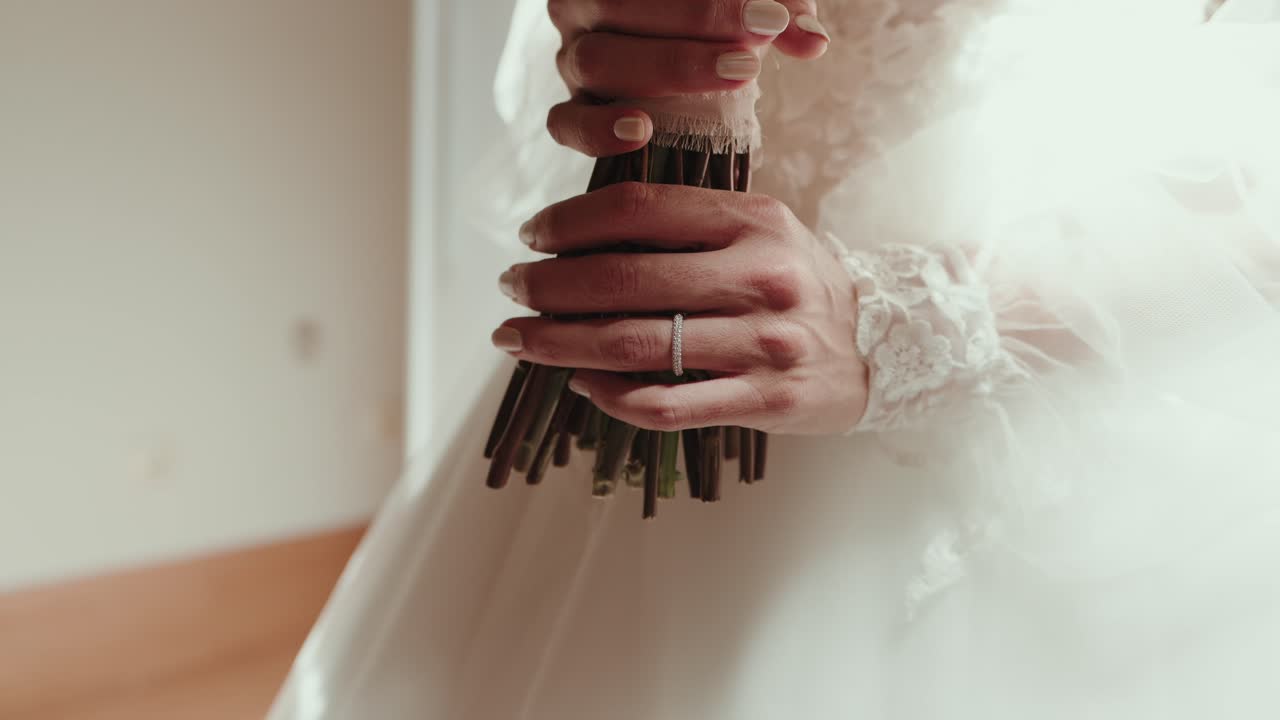 close up of bride holding wedding bouquet with delicate lace sleeve and engagement ring