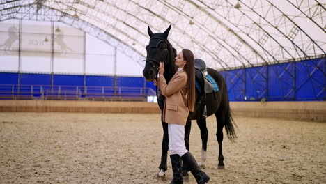 woman and horse in indoor riding arena
