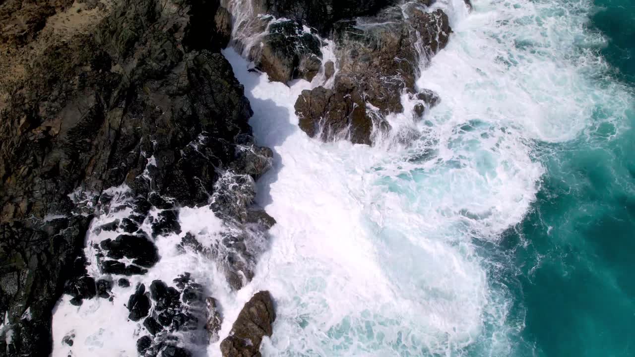 Vista aerea dall'alto di onde che si infrangono sul corallo ad Aruba