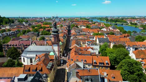 4k aerial drone video of historic homes, shops, and churches along the neckar river in downtown heidelberg, germany