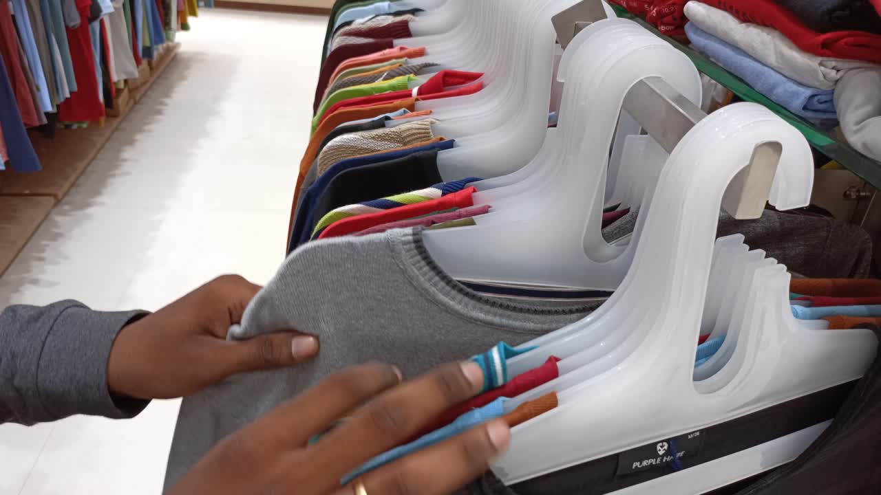 persona comprando ropa para hombres en un centro comercial