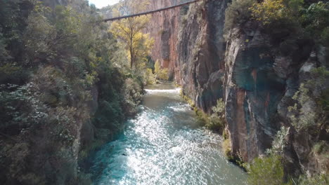 drone volando sobre el río al lado de un puente en valencia, españa