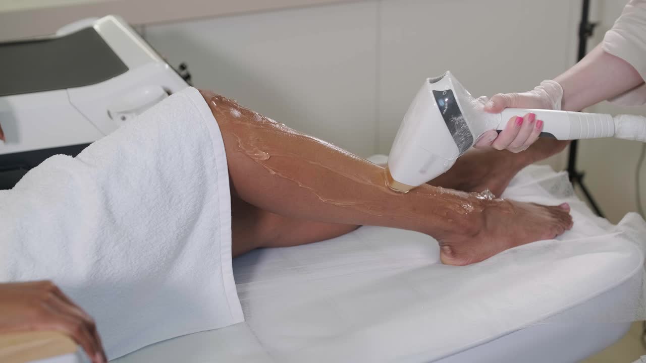 Laser epilation and cosmetology in beauty salon. Cosmetology, spa and hair removal concept. Laser hair removal procedure of female legs. doctor in gloves.