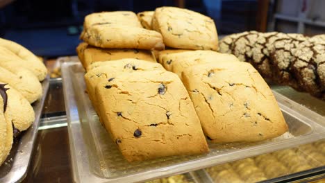 close-up of chocolate chip cookies on a display tray in a bakery
