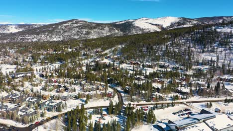 winter mountain town covered in white snow with cars driving and traveling through small neighborhood with beautiful outdoor background