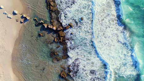 Wunderschöner-Drohnenblick-Auf-Wellen,-Die-An-Einem-Hellen,-Sonnigen-Tag-Mit-Lebendigen-Farben-Am-Strand-Krachen