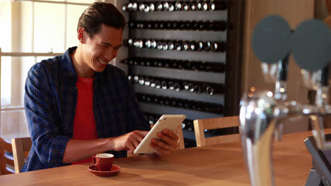 hombre usando tableta digital mientras toma café en el restaurante 4k