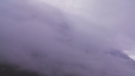 las nubes y la niebla revelan impresionantes montañas a lo largo de un fiordo en noruega