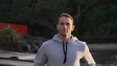 slow motion shot of fit caucasian man jogging on the beach in auckland, new zealand