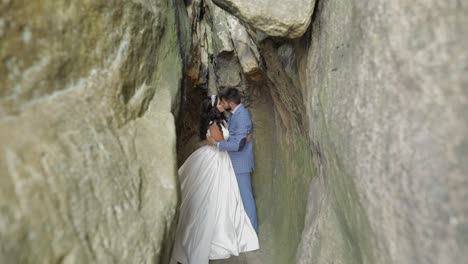 groom with bride standing in cave of mountain hills. wedding couple in love