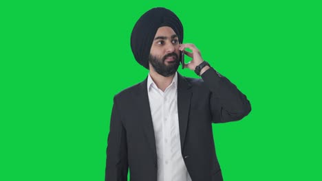 Serious-Sikh-Indian-businessman-talking-on-call-Green-screen