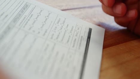 primer plano de un hombre de negocios sentado en un escritorio llenando un contrato