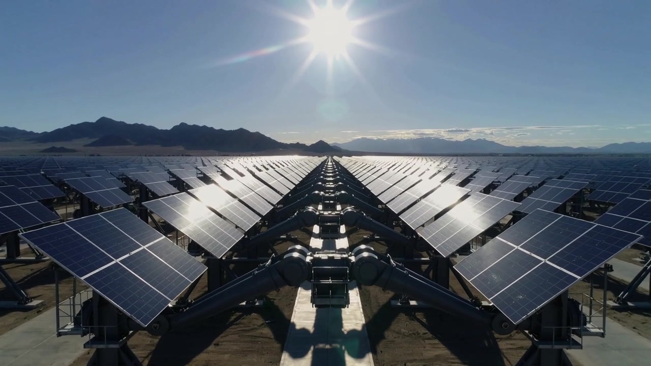 Telecamera in movimento che avanza in un impianto solare, catturando pannelli solari, strutture e l'orizzonte lontano