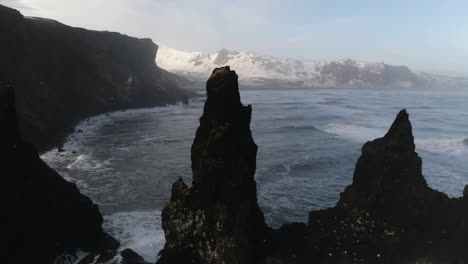 Vista-Aérea-Alrededor-De-Las-Imponentes-Rocas-Reynisdrangar,-En-La-Costa-De-La-Soleada-Islandia