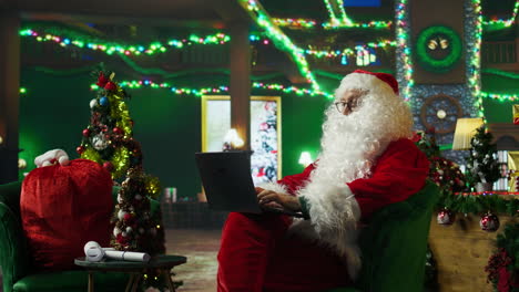 santa claus working on laptop during christmas