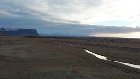 Car-driving-down-dirt-road-in-Iceland-during-sunrise