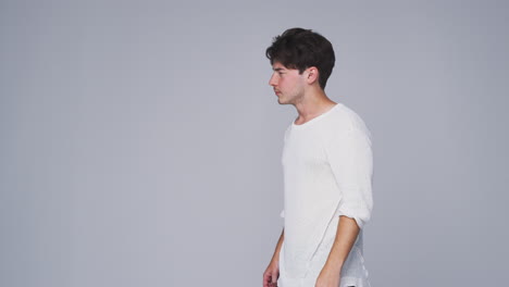 Studio-Shot-Of-Man-Walking-Into-Frame-Against-White-Background-And-Dancing-In-Slow-Motion