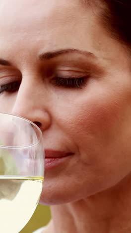 una viticultora girando un vaso de vino blanco
