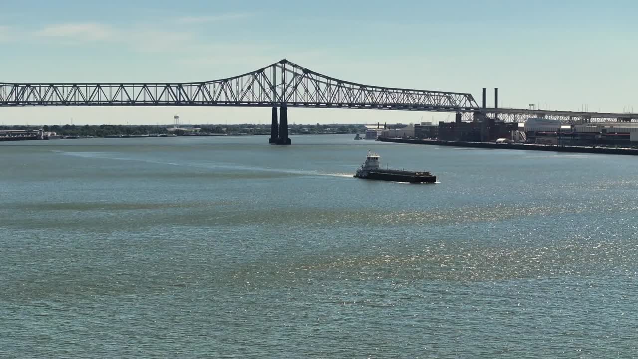 Pushboat and barge coasting along the Mississippi River near New Orleans