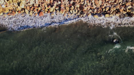 coastal view of rocky shoreline with clear water during sunny weather