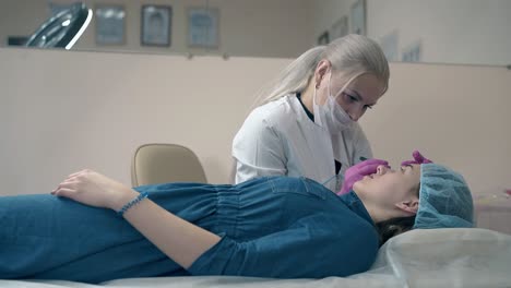 woman-uses-tweezer-to-work-with-client-brows-slow-motion