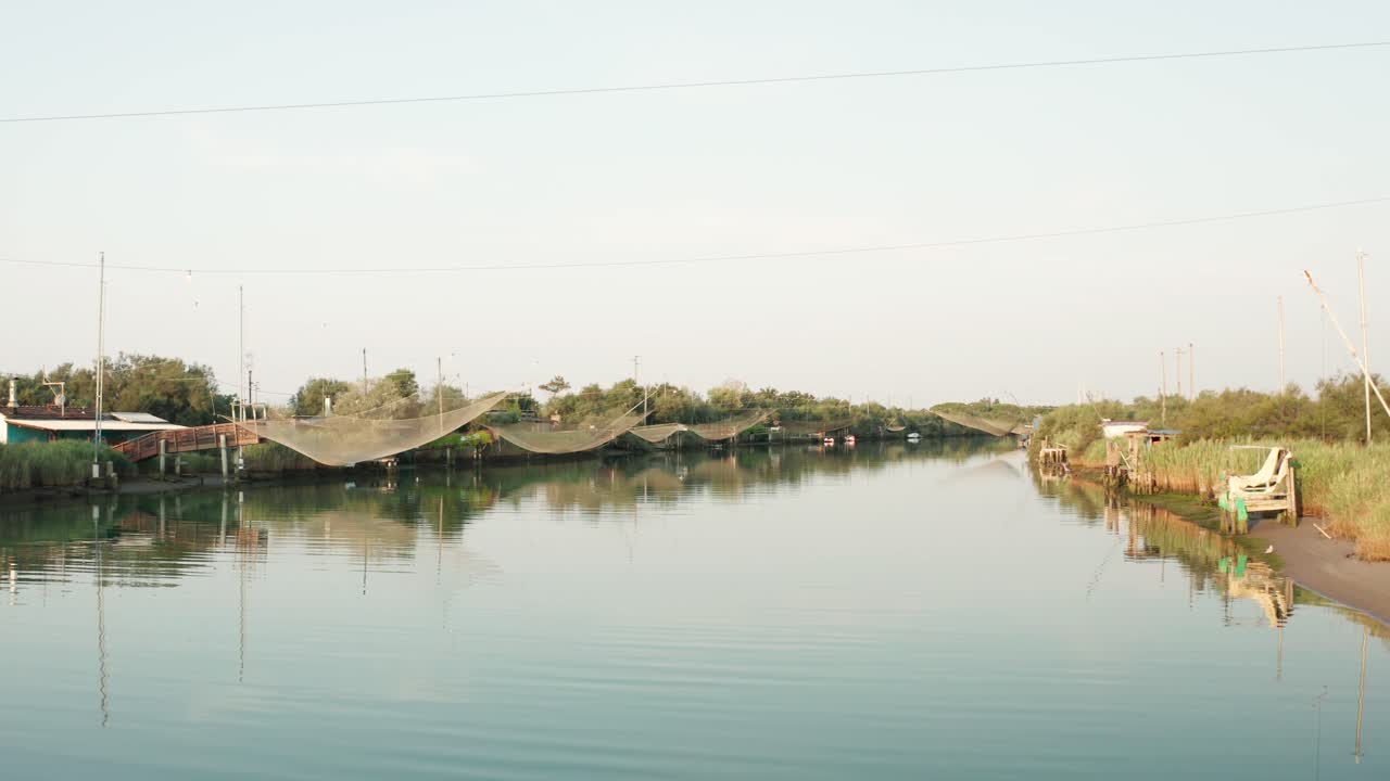 paisaje de cabañas de pesca en el río con la típica máquina de pesca italiana, llamada ""trabucco"",lido di dante, fiumi uniti ravenna cerca del valle de comacchio