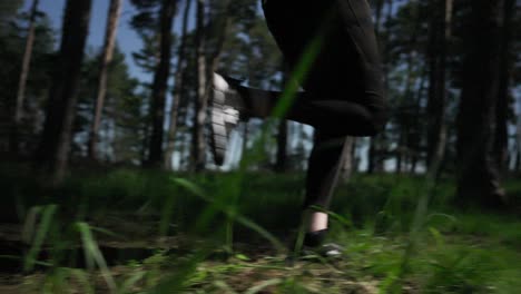 a woman in running clothes runs past the camera in a sunlit forest