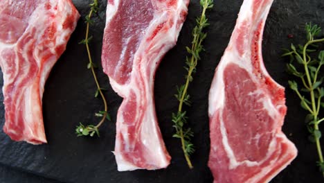 meat chops and rosemary kept in a row