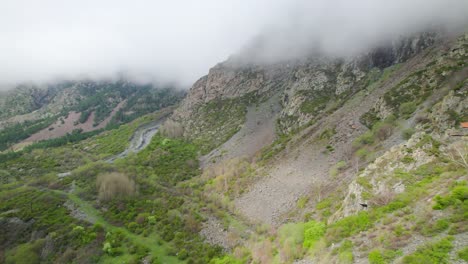 Birds-pov-soaring-through-mountains-under-cloudy-sky