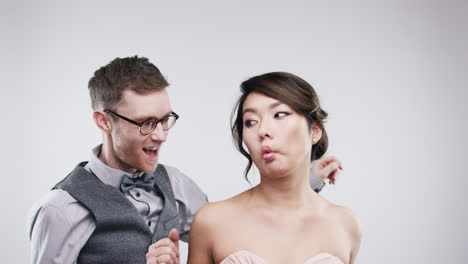 pareja geek tirando caras divertidas en cámara lenta serie de cabina de fotos de bodas