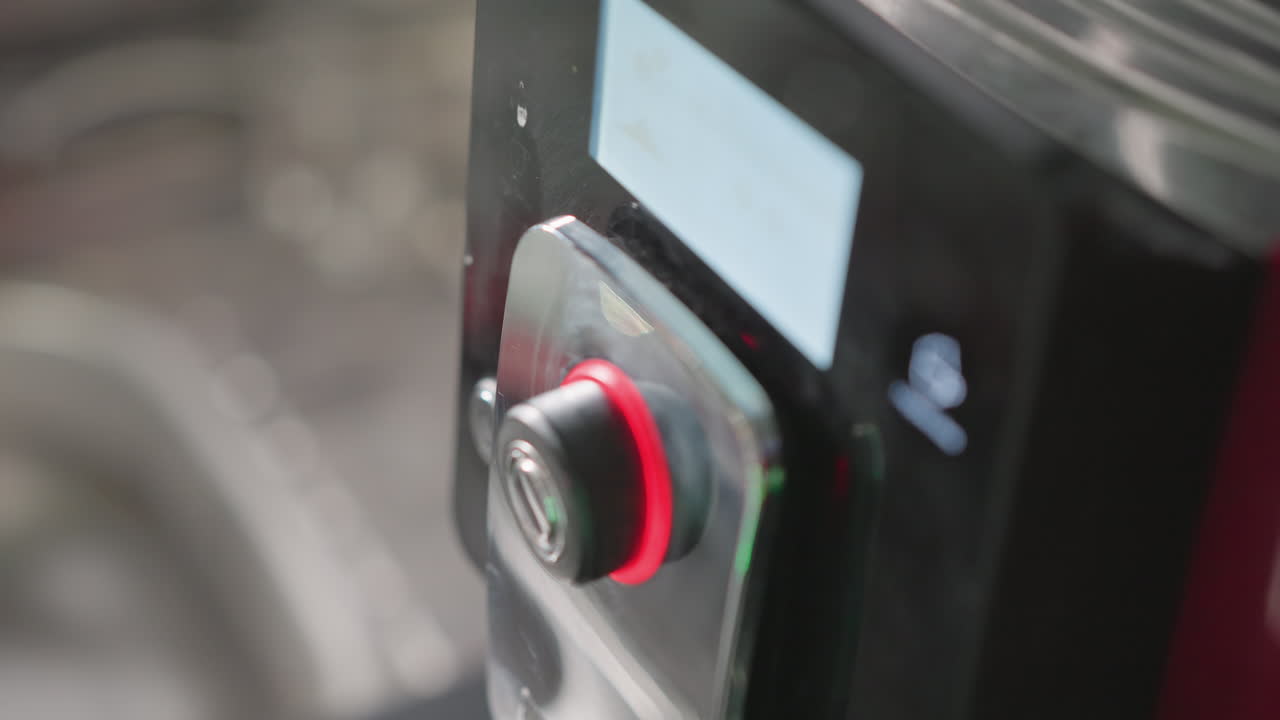 Close-up of hand turning knob on coffee machine's control panel, selecting coffee settings, with focus on precision and interaction with appliance in home or office kitchen
