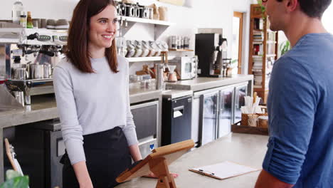 Man-making-contactless-smartphone-payment-at-a-coffee-shop