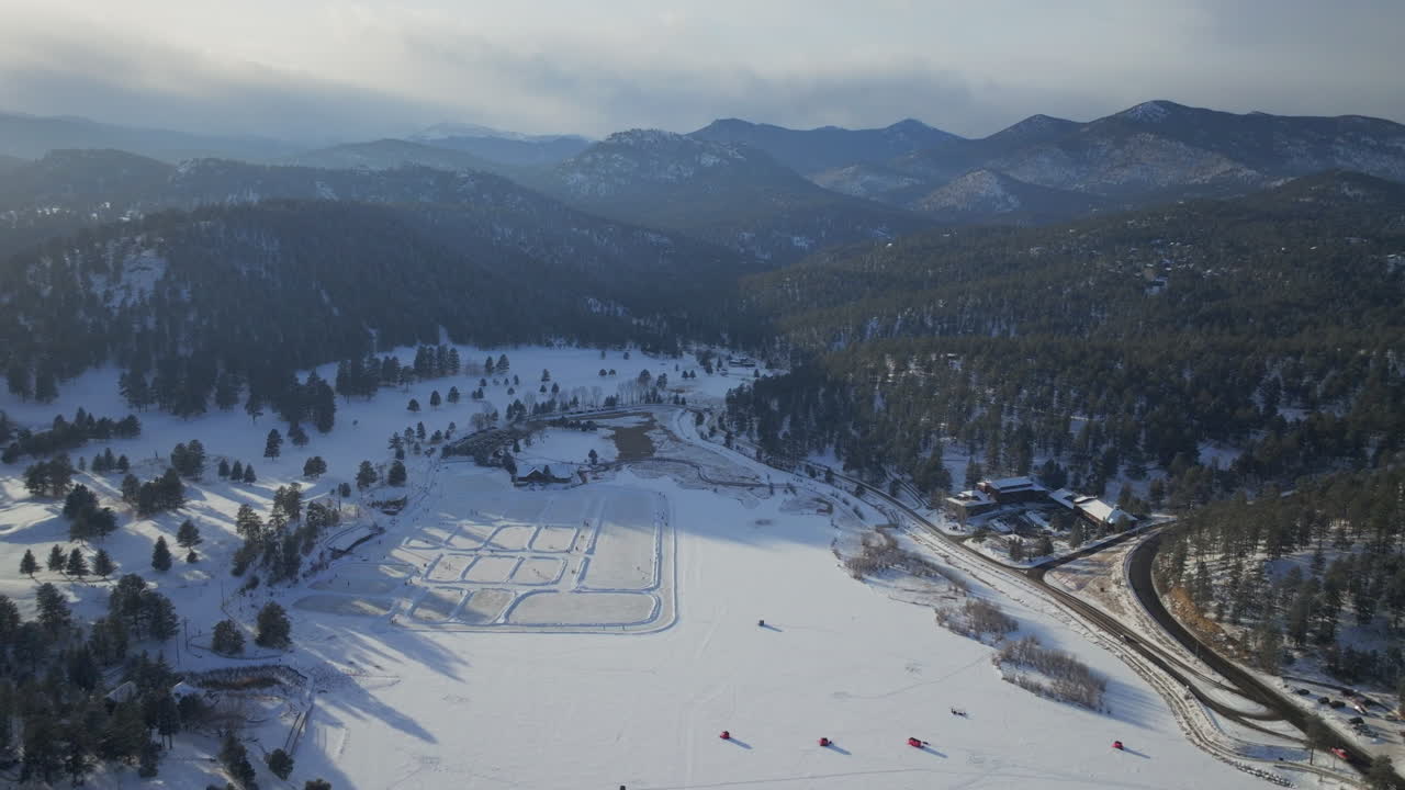 Tramonto Pattinaggio su ghiaccio pista di hockey lago stagno hockey inverno casa sul lago Evergreen di Etown tende da pesca campo da golf di Denver Colorado drone cinematografico aereo ora d'oro neve invernale traffico movimento all'indietro