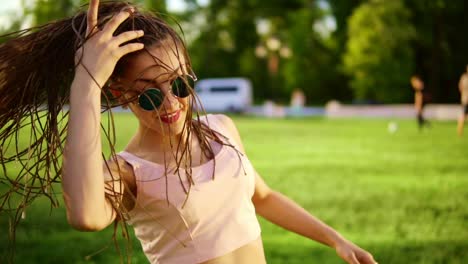 Junges-Schönes-Mädchen-Mit-Dreadlocks,-Das-In-Einem-Park-Tanzt.-Schöne-Frau-In-Jeans-Und-Sonnenbrille,-Die-Musik-Hört-Und-Tanzt