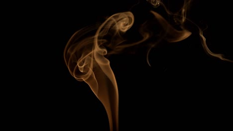 smoke on black background. light so illuminates the smoke that it looks orange.