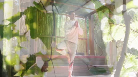 animation of leaves over caucasian man practicing yoga and meditating