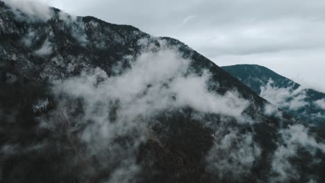 atmospheric and moody drone footage of mountainous landscapes in austria with wet and misty conditions