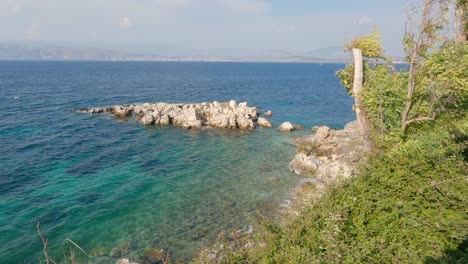 Vista-Del-Paisaje-Y-La-Costa-Rocosa-De-Kassiopi-En-La-Isla-De-Corfú,-Olas-En-El-Mar-Turquesa