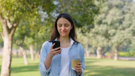 chica india bebiendo café en un parque
