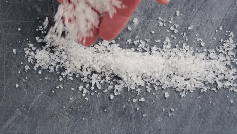 hand sprinkling salt on a cutting board