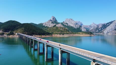 Vista-De-Drones-Del-Puente-Riaño-En-Primer-Plano-Y-Las-Montañas-De-Fondo