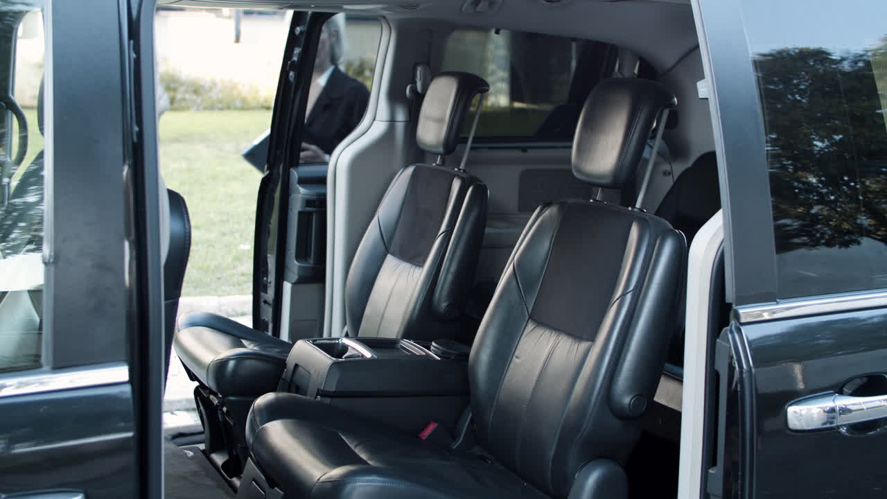 gente de negocios entrando en un auto negro y dándose la mano