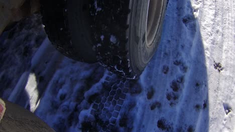 dual wheels on a grain truck driving across a snowy farmyard