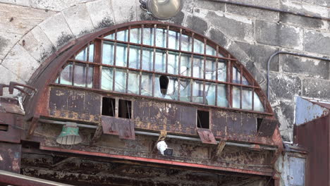 rusted arched window with cracked glass